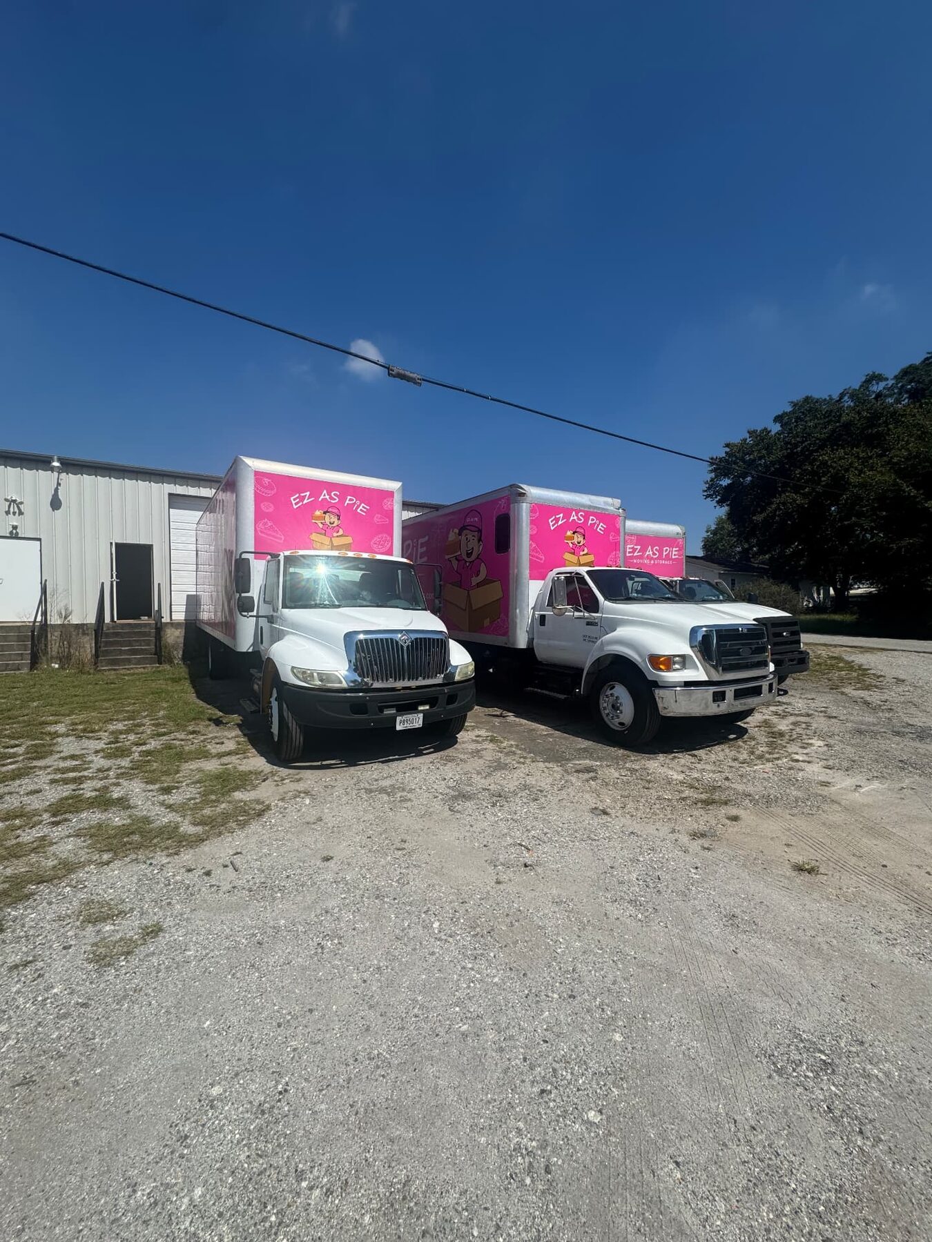 Three EZ As Pie pink moving trucks lined up at our facility